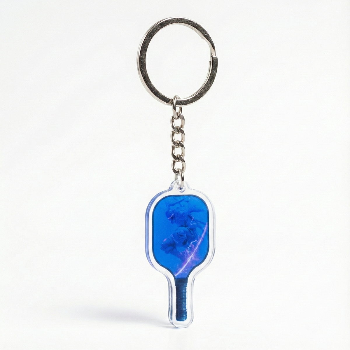 Keychain shaped like a pickleball paddle with a blue design on a white background