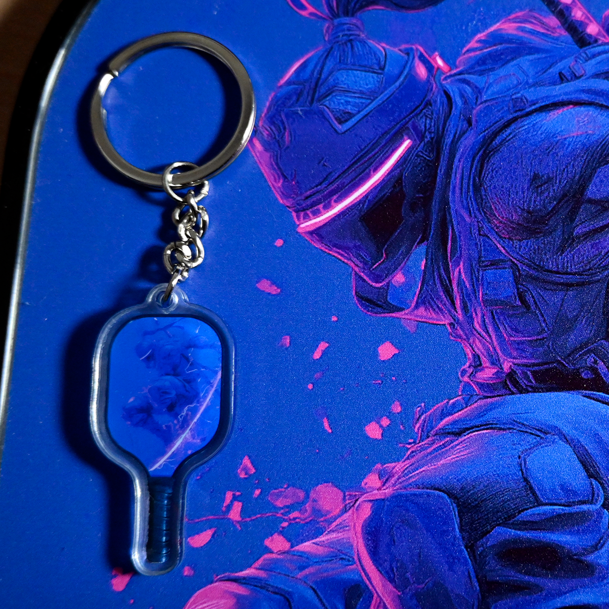 Keychain with a blue and pink character design on a matching background