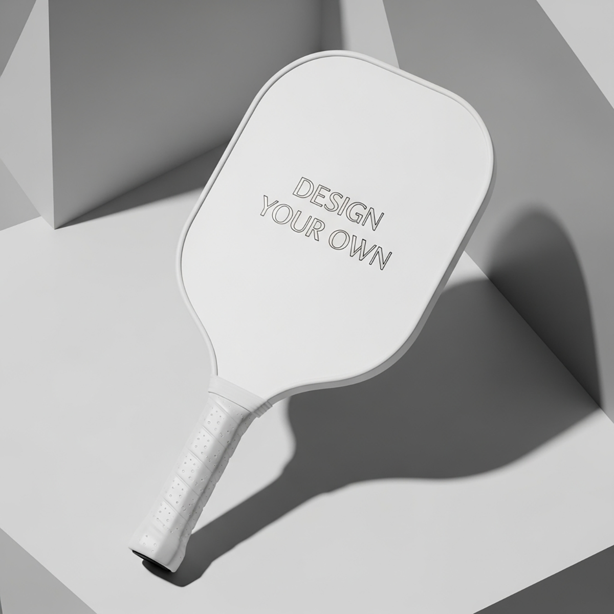 White paddle with 'Design Your Own' text on a geometric gray background